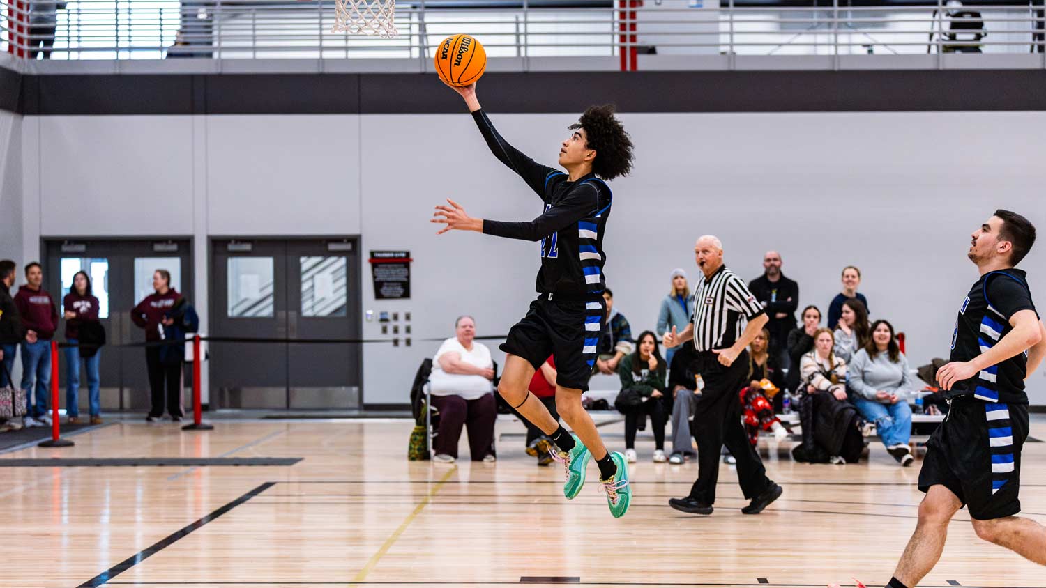 Photo of a high school basketball player jumping toward the basket.